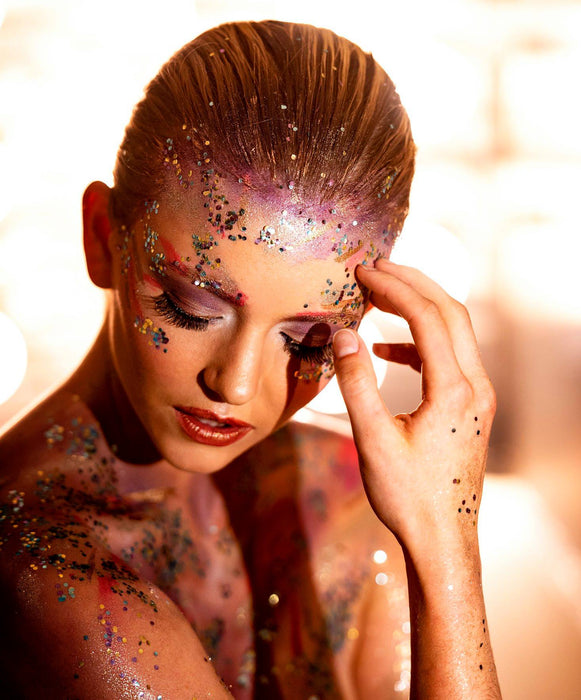 Creative makeup by Saskatoon Makeup Artist Jennilee Cardinal-Schultz using Biodegradable Glitter. Woman with glittery makeup and body art against a bright background