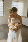 Makeup work by Saskatoon Makeup Artist Jennilee Cardinal Schultz for Bridal Parties and Weddings. Photos by Chelsea Pratchler. Saskatoon Bride in a white lace wedding dress holding a bouquet of flowers in an indoor setting.