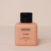Body cream bottle labeled 'routine' on a beige background