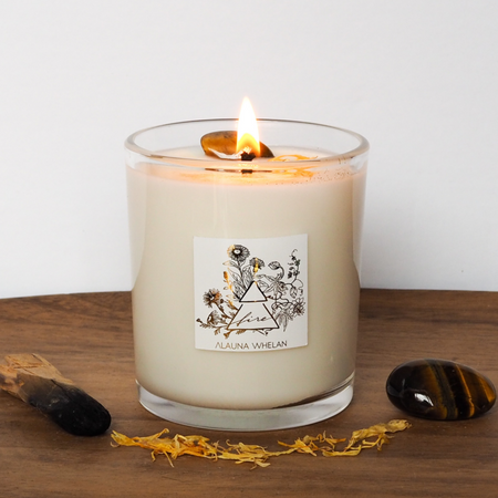 lit soy crystal infused fire element abundance intention candle on wooden tray
