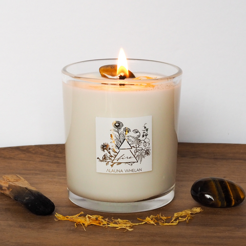 lit soy crystal infused fire element abundance intention candle on wooden tray