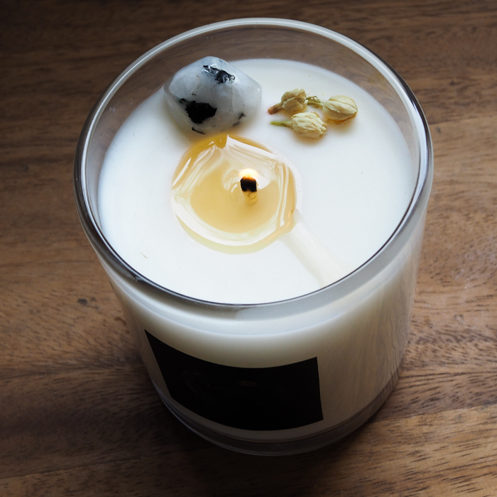 top view of full moon soy candle with white crystal and flowers